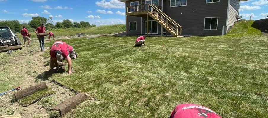 Frontline workers installing sod to landscape in Altoona, IA.