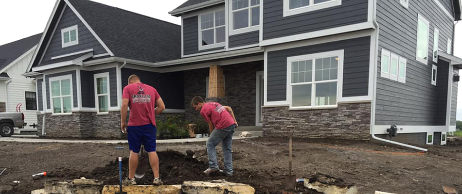 Workers installing landscape bed in Bondurant, IA.