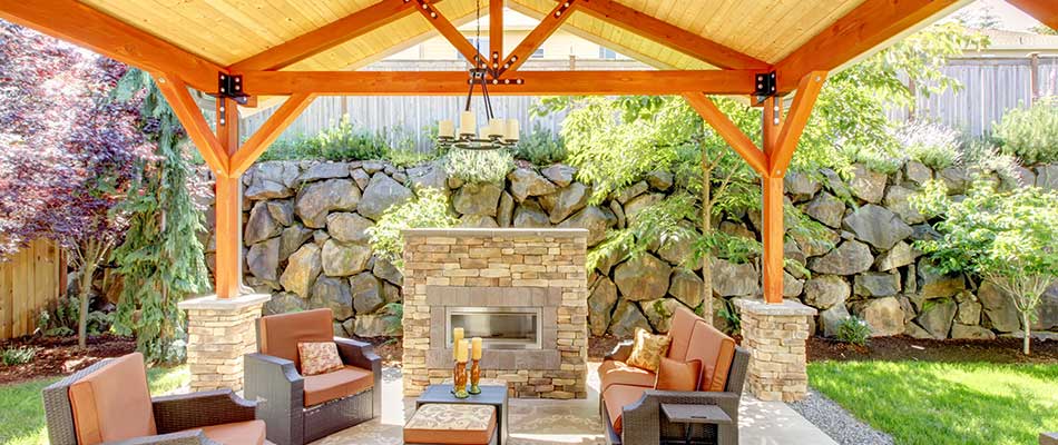 Outdoor living area with fireplace and seating under a pavilion near Bondurant, IA.
